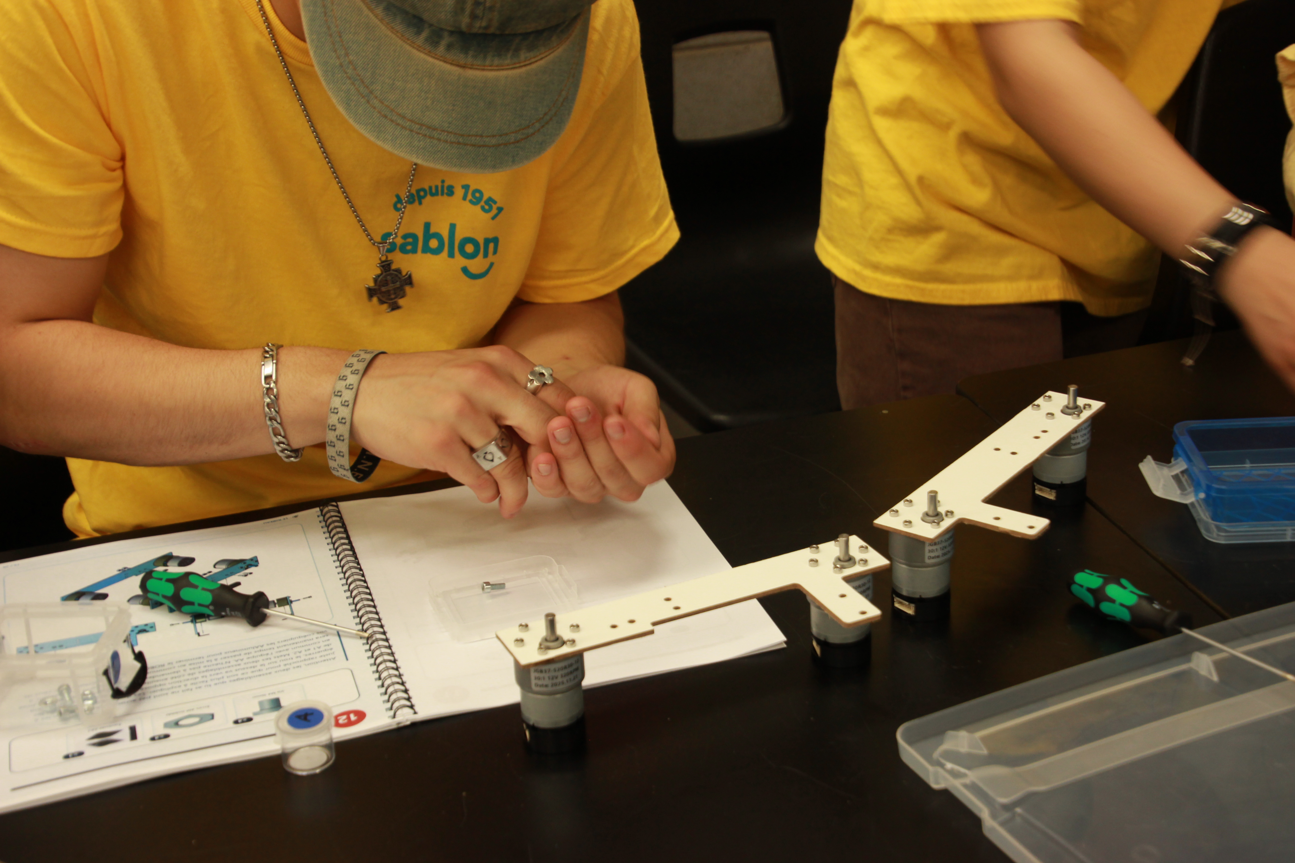 Jeunes qui assemblent un robot pendant le camp de robotique
